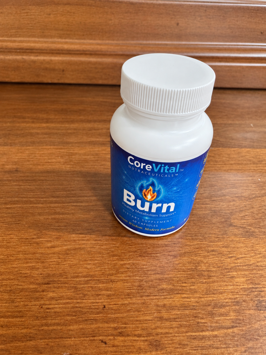 CoreVital Burn bottle standing on a wood surface, with the blue front label visible